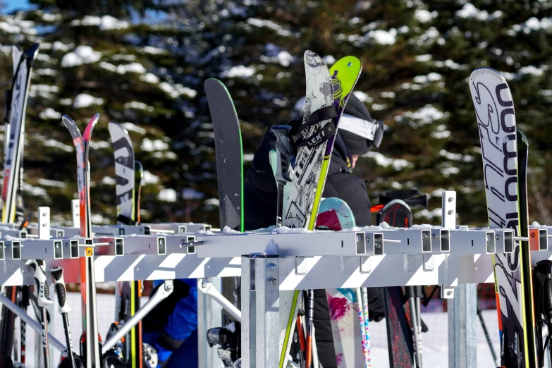 several skis stuck up against a metal rail