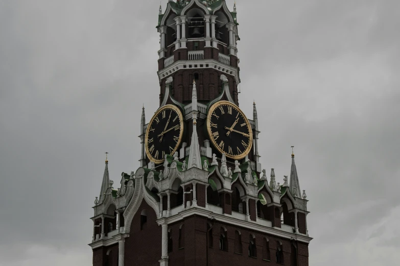 a tower with two clocks against a grey cloudy sky