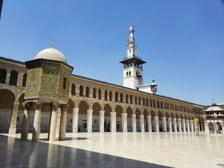 some white and yellow columns with a bell tower in the background