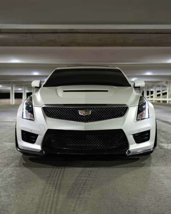 the front end of a white cadillac with a black strip