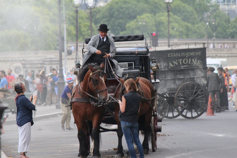 two men on horses being led through an event by a wagon