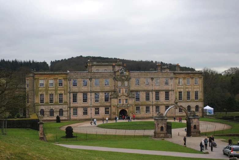 a group of people walk down the path next to a building