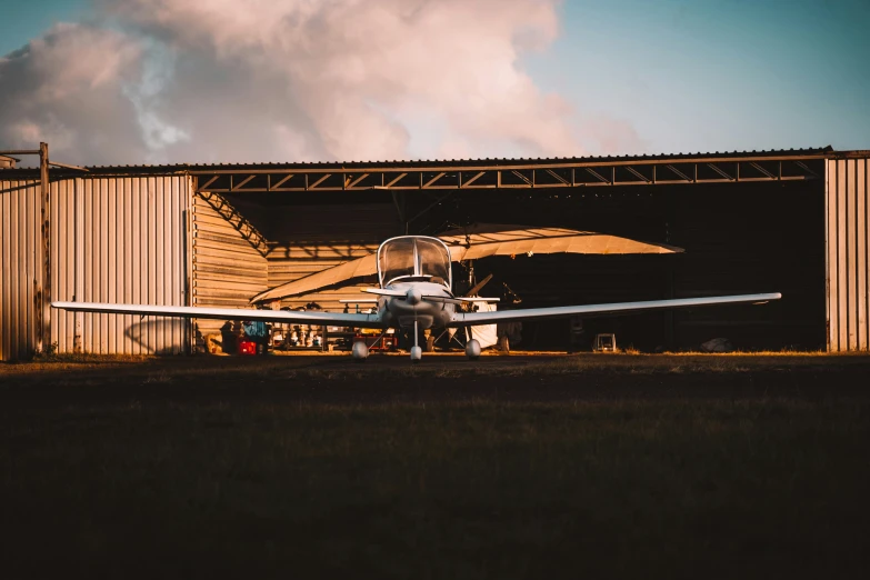 an airplane is parked next to a barn