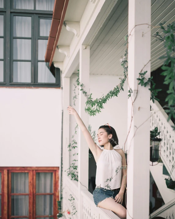 a woman sits on a porch with her arm up