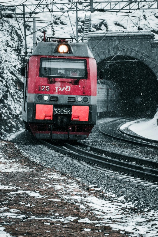 train traveling along tracks near a snow covered hill