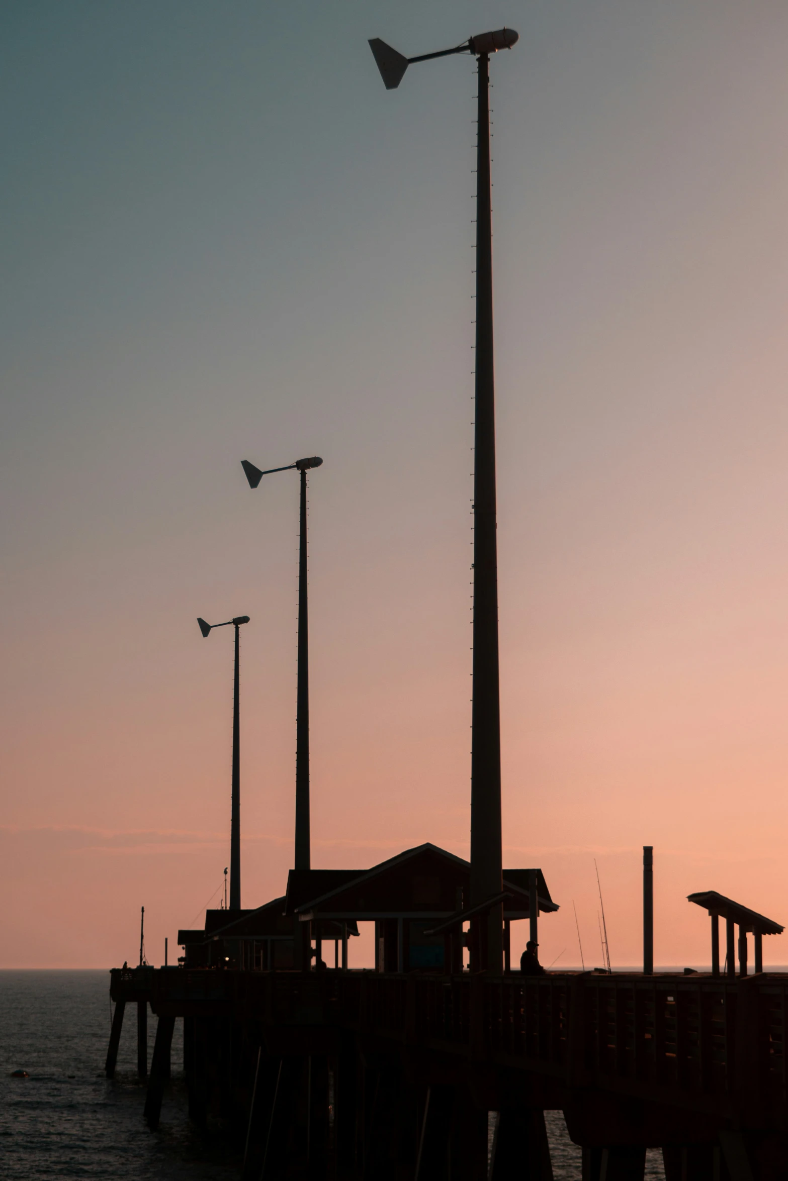 the lights are on along the pier at dusk