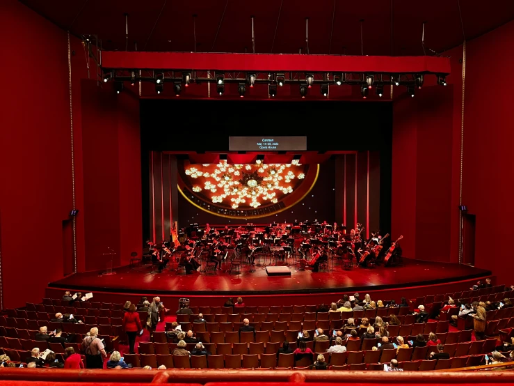 an auditorium with a stage filled with people playing and watching