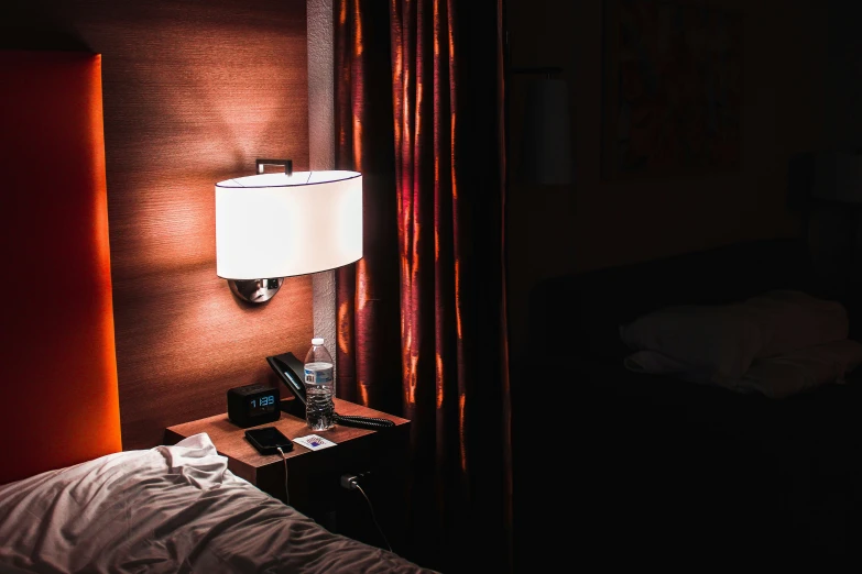 this is a dark room with a lamp and bed