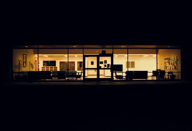 a large glass building lit up by street lights