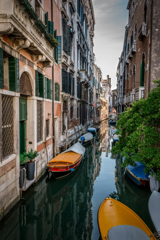 a bunch of boats parked at the end of a small river