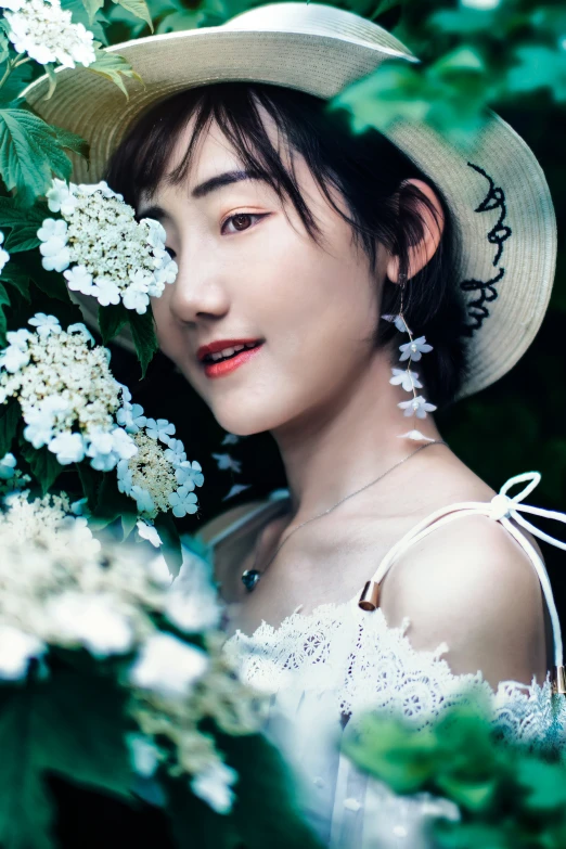 a woman with a flowered hat on is posing for the camera