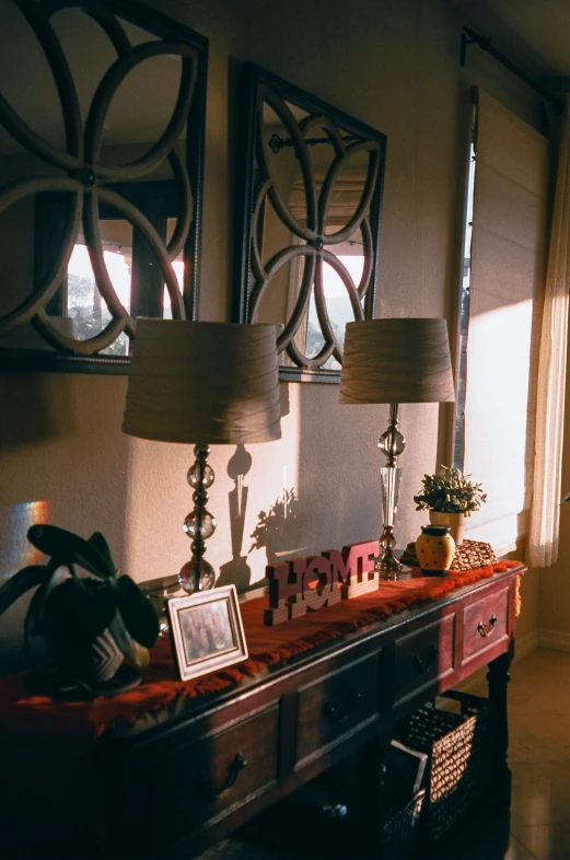 a buffet table with two lamps and pictures