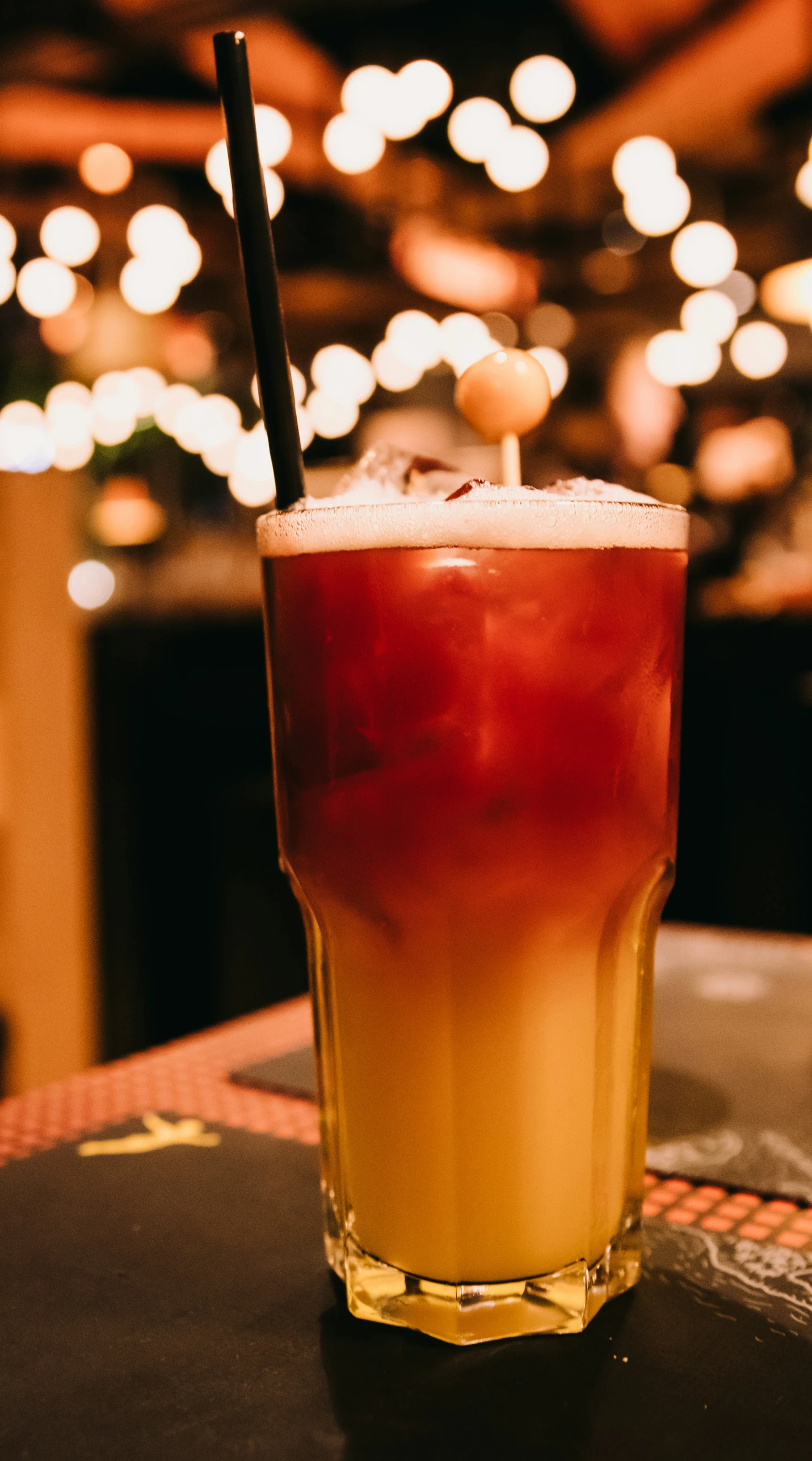 a glass with a straw sits on a bar