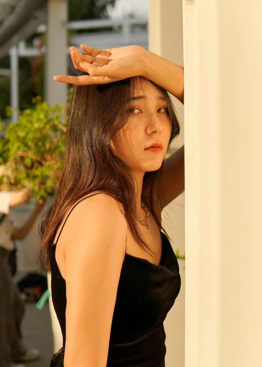 a young woman holding her head on the side of a wall