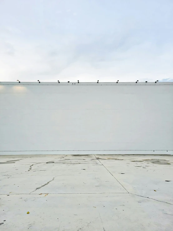 a view of an empty parking lot with birds perched on the wall