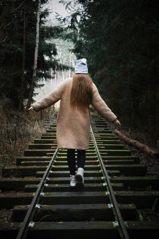 someone on a railroad track with their arms outstretched