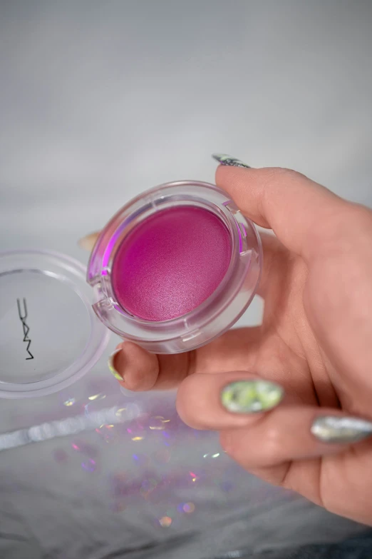 woman's hand holding purple powdered eye shadow