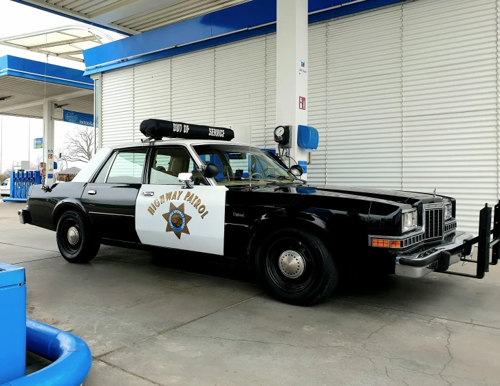 an police car parked in front of a white and blue garage