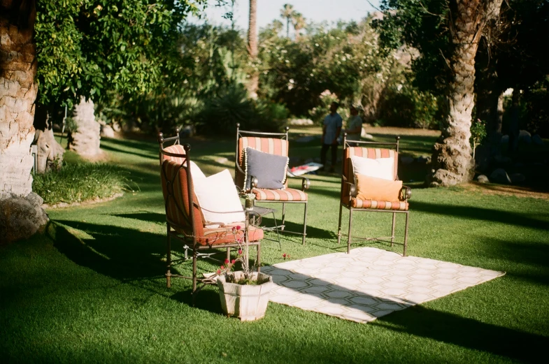 two chairs and an ottoman sit on grass