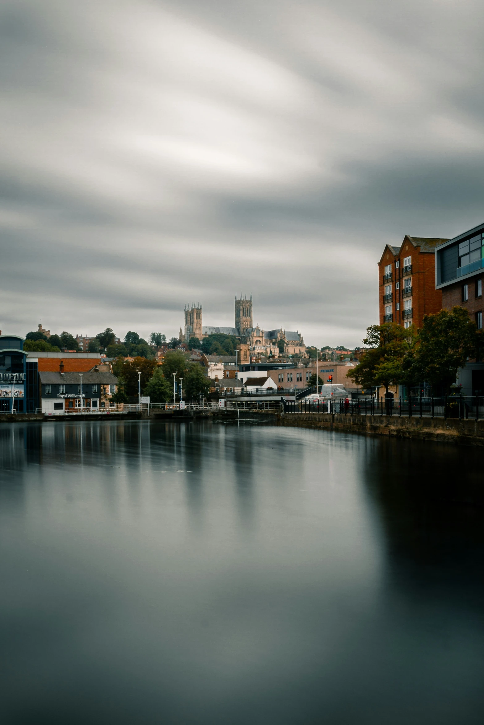 a body of water surrounded by houses with a tall clock tower in the background