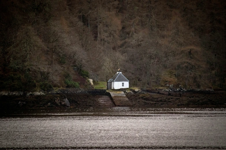 a white building is sitting in the middle of a body of water