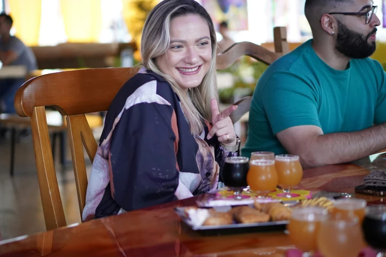 the girl is smiling at the table full of breakfast items