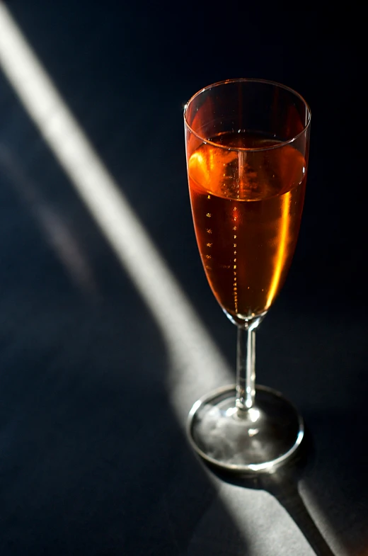 a glass with some liquid on a dark surface