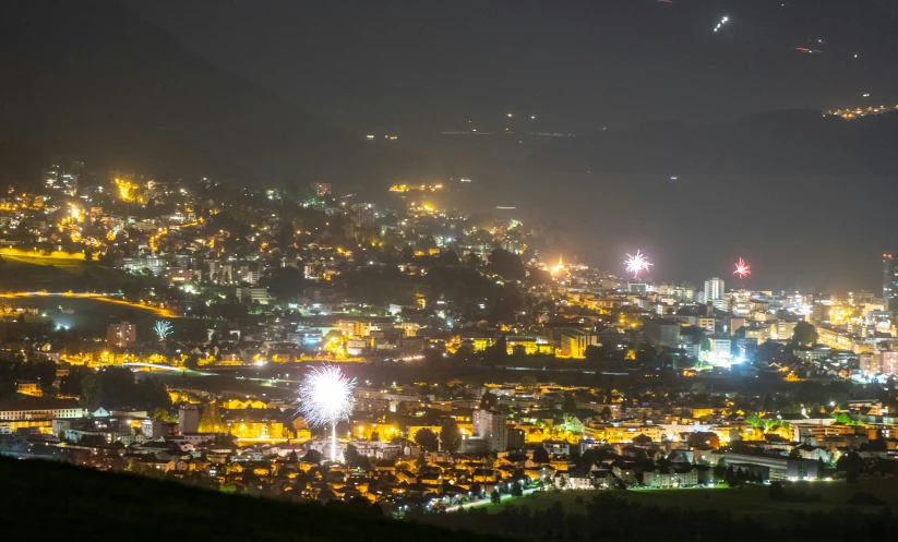the city lights shine bright over the hills