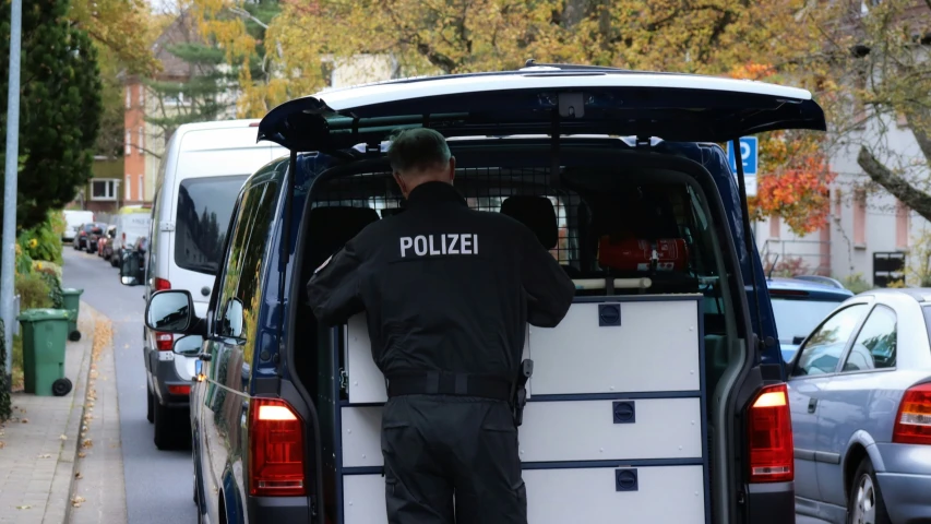 a police officer is standing in the back of a van