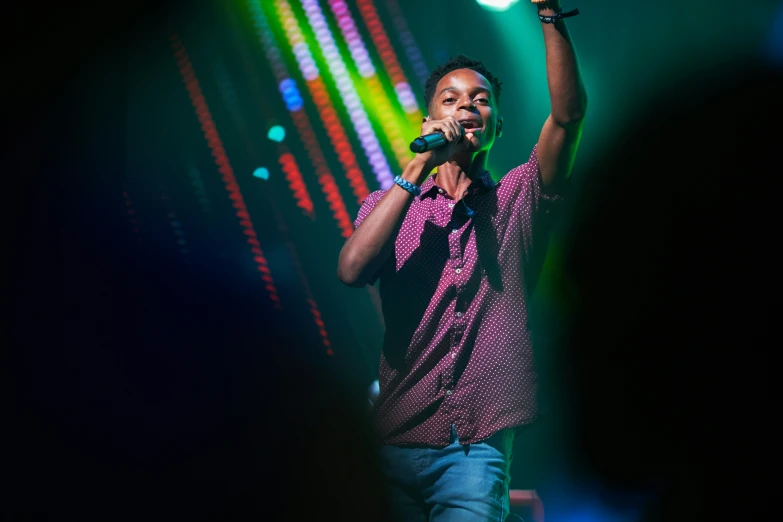 a man standing on top of a stage holding a microphone