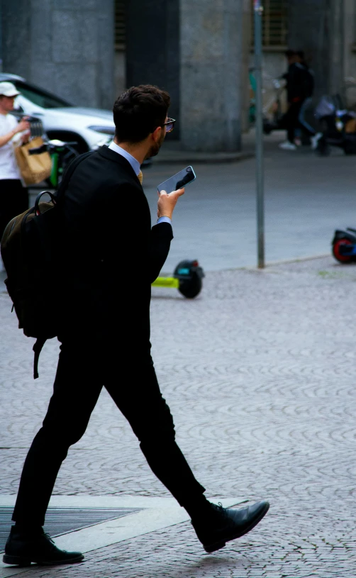 a man walking on the street while looking at his phone