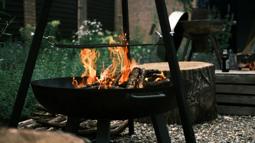 a fire in the center of a black bowl outside