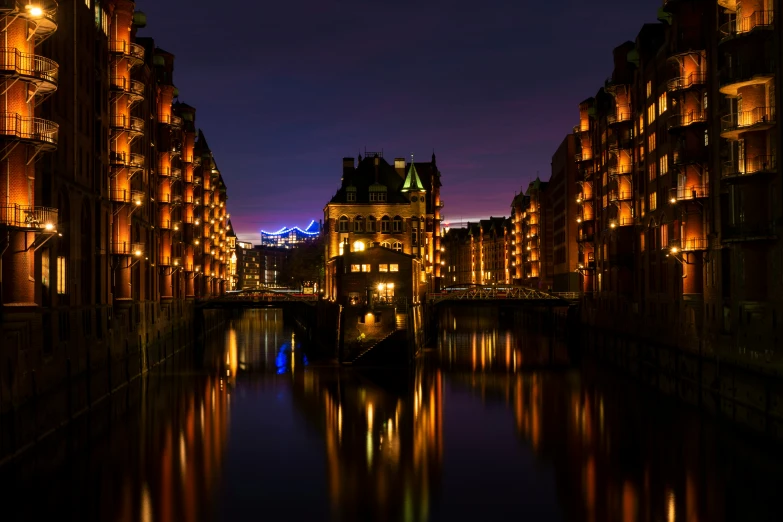 a canal running between two buildings at night