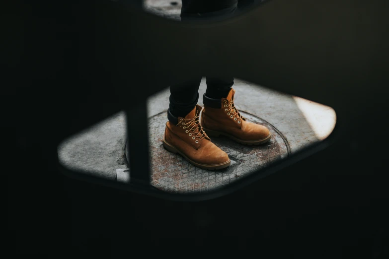 a person's feet in high - top shoes with brown laces