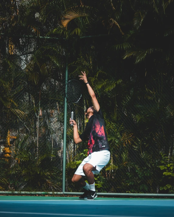 a tennis player reaching up to hit a ball