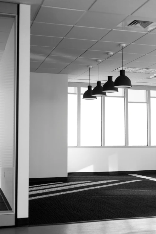 a large office building has three light bulbs hanging above the office area