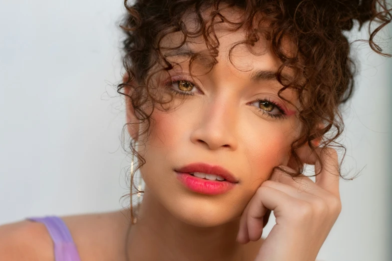 a young woman with her hair in a curly, messy, up do with pink lipstick