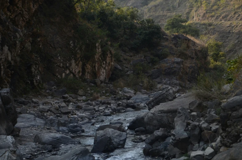 a stream runs between some large rocks in a valley