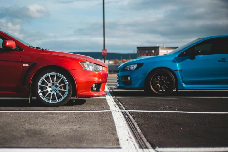 two cars parked next to each other on a parking lot