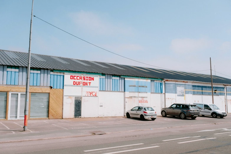 two cars parked in front of a warehouse