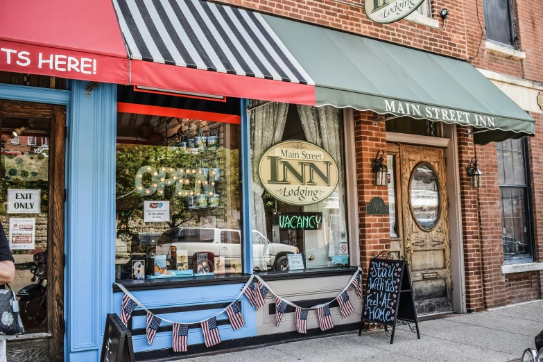 a blue store front is decorated with red, white and blue flags