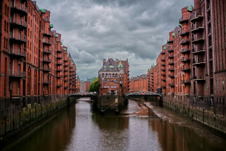 a narrow waterway on a rainy day surrounded by buildings