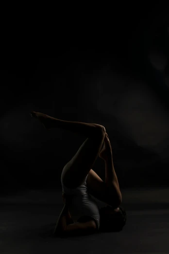 a woman that is sitting on the floor in the dark