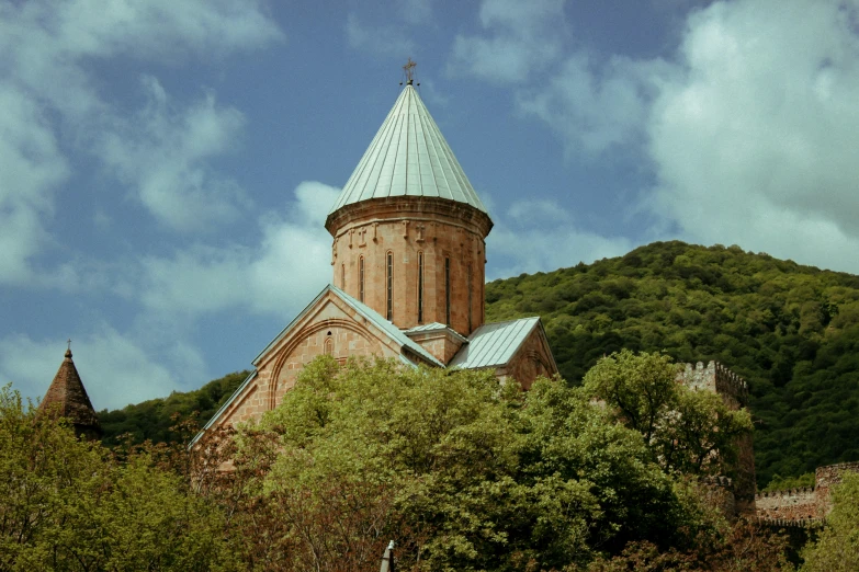 a very tall tower on top of a green mountain