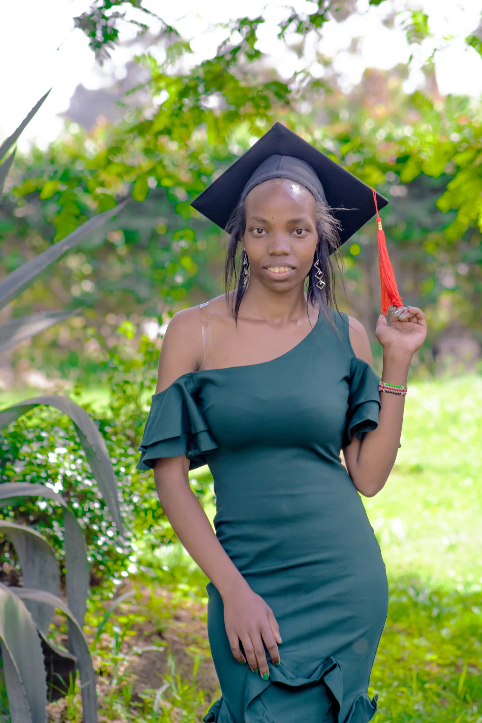 a woman is posing with a graduation cap