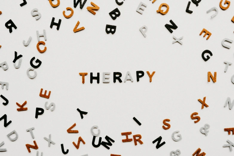 the word therapy spelled out with letters, and an orange lettering