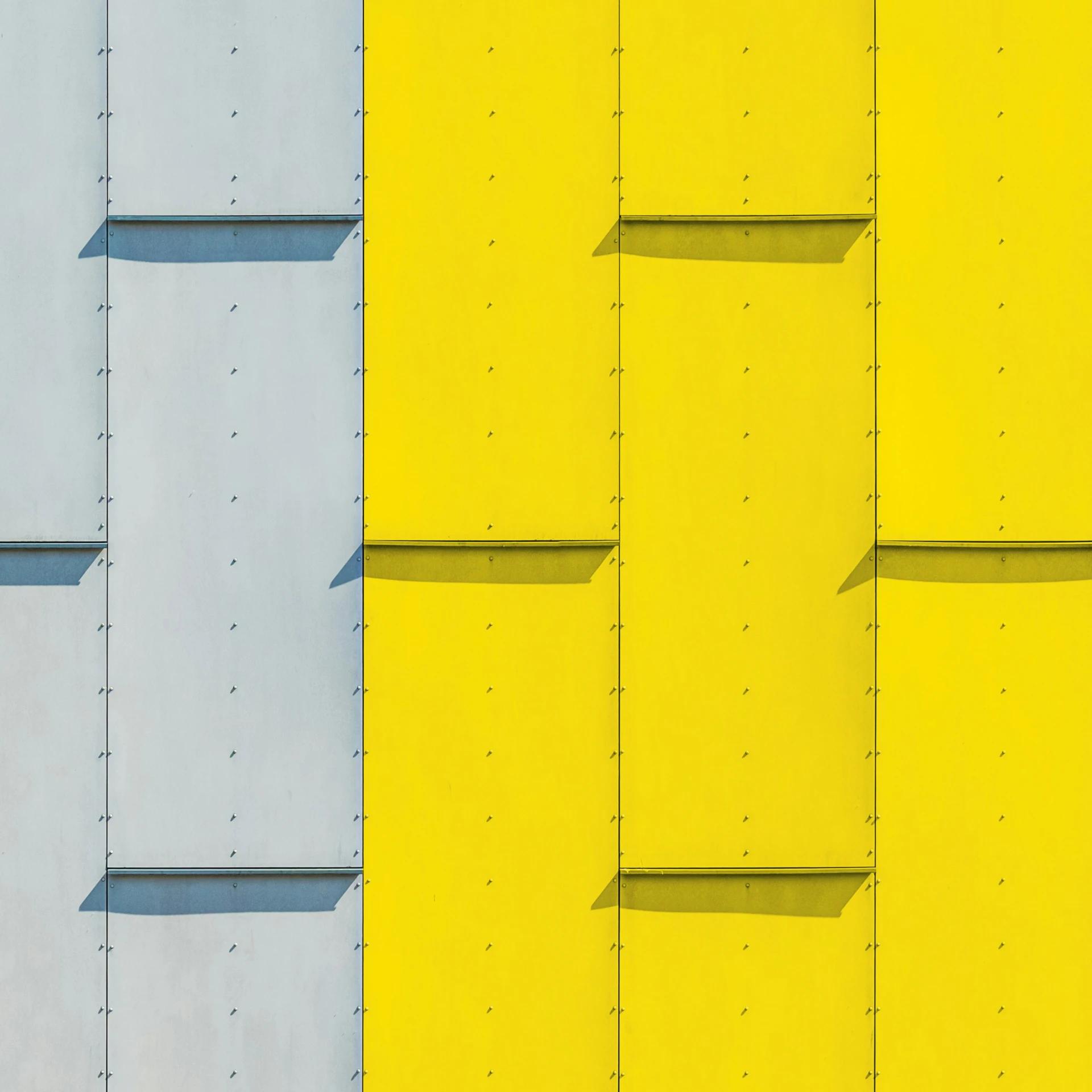multiple colorful panels covering a building on a sunny day
