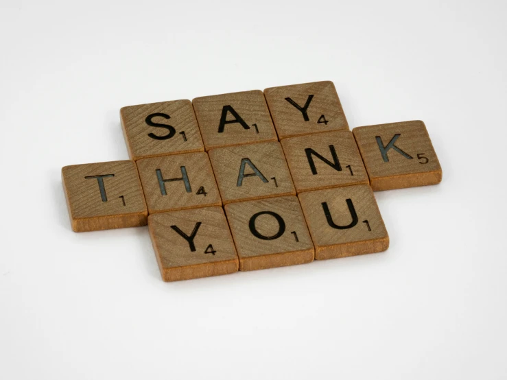 the words say thank and thank you in wooden blocks