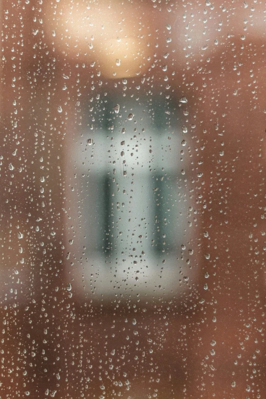 rain drops are falling on a window outside