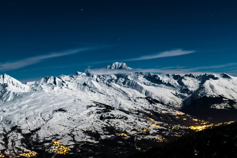 a view from the top of a snowy mountain at night